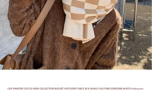 Detail of soft fuzzy knit cardigan paired with a beige and brown checkerboard scarf