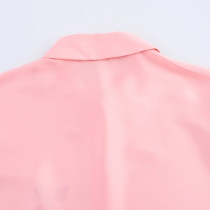 Gros plan détaillé du col et des épaules de ce chemisier en satin rose à fleurs