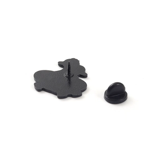 Rear view of cute cartoon duck enamel pin with black rubber clutch on white background