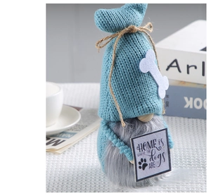 Detail of blue knitted gnome with grey beard holding 'Home is where the dogs are' sign