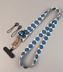 Detailed view of adjustable crossbody phone strap with blue patterns and gold metal buckle