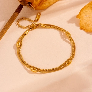 Detail of double-layer stainless steel bracelet with snake chain and gold oval beads