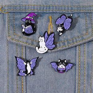 Set of 5 purple magic cat enamel pins with wizard hats on blue denim jacket