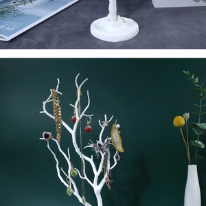 White tree-shaped jewelry organizer stand with various necklaces and earrings on display