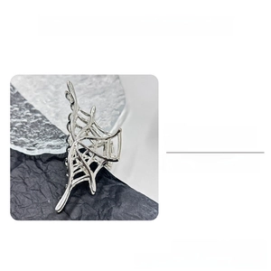 Detailed view of silver spiderweb claw clip showing industrial metal alloy texture