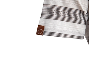Gros plan du poignet de polo à rayures avec texture en maille et étiquette tissée