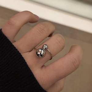 Macro detail of minimalist dual spherical stainless steel ring on a finger