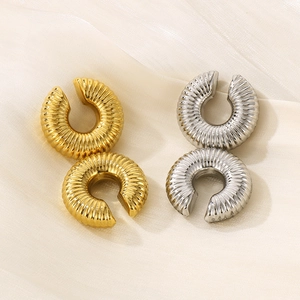 Detailed view of hollow C-shaped ear cuffs in gold and silver with textured surface