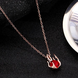Detailed close-up of a gothic red heart pendant with rose gold flame wrapping effect