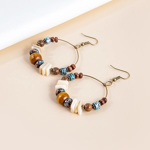 Macro detail of Bohemian beaded hoop earrings with wood beads and bronze hooks