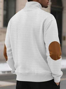Detail view of waffle texture fabric and brown elbow patches on white knit sweatshirt