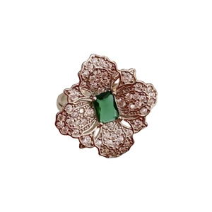 Silver flower ring with green square gemstone and zircon pavé petals on white background