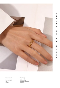 Detail of adjustable gold chain ring on model hand with minimalist fashion background