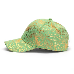 Détail d'une casquette vert clair avec motif complexe en feuille d'or imprimé amour