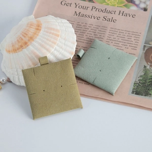 Macro detail of microfiber jewelry card holder in olive and mint with pearl accents
