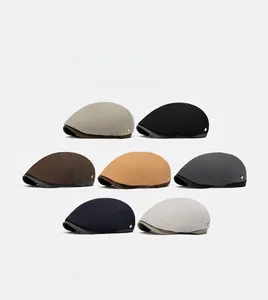 Detailed collection of seven vintage style flat caps in various colors with metal logo side detail