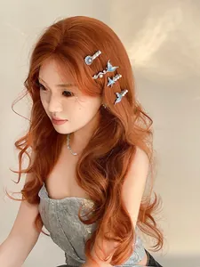 Detail of fishtail and shell hair clip with blue enamel and pearls on wavy hair