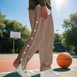 Detail of brown hip-hop joggers featuring side snap buttons and contrast stripes on field