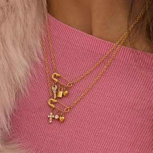 Golden double-layer paperclip necklace featuring heart, lock, and key charms on a pink outfit