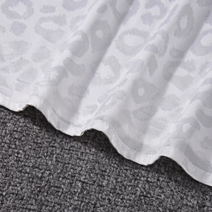 Gros plan sur satin blanc à motif léopard montrant les coutures et la texture lisse