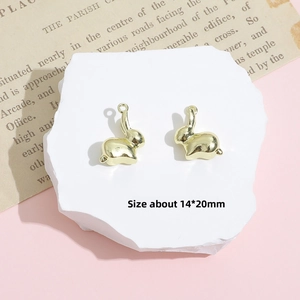Macro shot of 14x20mm gold rabbit charms for DIY jewelry making on white stone