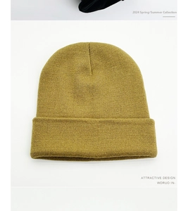 Detail of mustard yellow knit beanie showing fine horizontal weave and classic cuffed brim