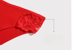 Close-up of red ribbed cotton panties showing intricate floral lace detailing and side seams