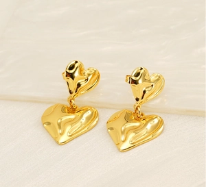 Detailed view of gold double heart earrings with organic textured lava metal finish