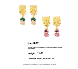 Detail of vintage textured gold titanium earrings with green and purple natural stone beads