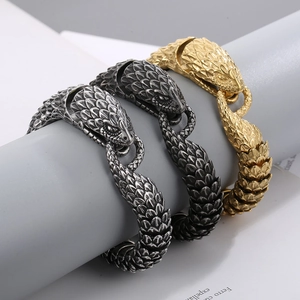 Detail of snake head bracelets in silver, gold, and black with textured metal scales
