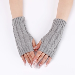 Macro shot of grey cable-knit texture on fingerless arm warmers for autumn and winter