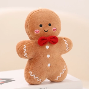 Detailed close-up of a brown plush gingerbread man doll with a red bow and embroidery