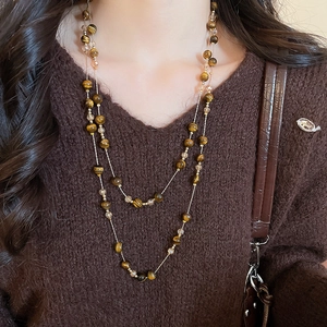 Close-up of double-layer necklace with tiger eye beads and champagne crystals on a sweater