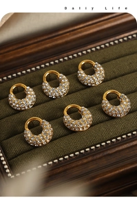 Détail de 6 boucles d'oreilles créoles dorées avec strass pavés sur velours