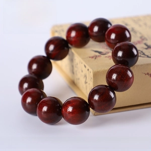 Close-up of 20mm Argentinian green sandalwood beads on a vintage yellow gift box