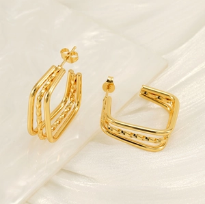 Detailed view of layered golden geometric earrings with textured twist patterns