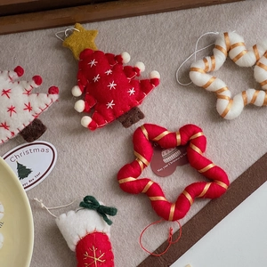 Detail of wool felt Christmas ornaments with embroidered snowflakes and festive hanging cords