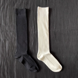 Detailed texture of rib-knit black and white Japanese style cotton over-the-calf socks