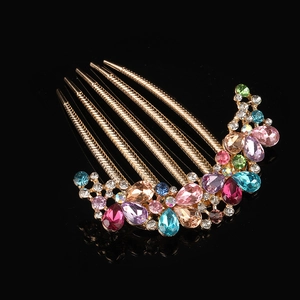 Elegant gold metal hair comb with colorful rhinestones and gemstones on black background