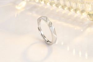 Detail of silver couple ring featuring geometric cut band and three micro-set zircons