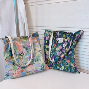 Detailed close-up of two floral canvas tote bags in pink and dark green oil painting styles