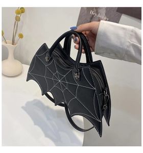 Detailed view of black bat shaped bag featuring silver gothic cross hardware and spiderweb stitching