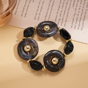 Macro shot of chunky marble resin beads and golden metal accents on a retro necklace