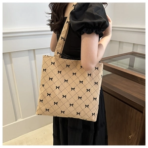 Sac fourre-tout en velours côtelé avec nœuds noirs et motif à carreaux porté par femme