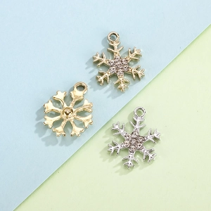 Golden and silver snowflake charms with rhinestones on a blue and green background