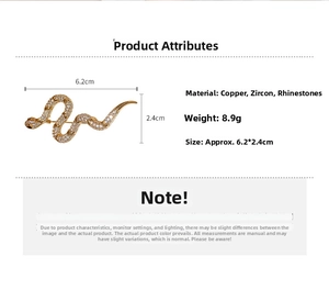 Detail of gold plated snake brooch with cubic zirconia, size 6.2cm x 2.4cm on white background