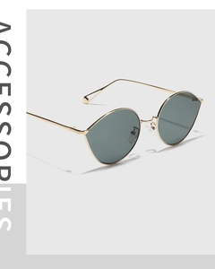 Détail de lunettes de soleil ovales tendance en métal avec monture dorée et verres foncés