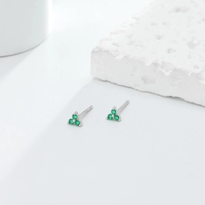 Detailed close-up of S925 silver triangle stud earrings with three green emerald stones