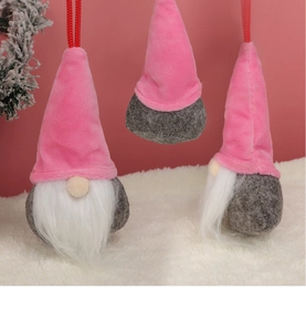 Drei hängende rosa Waldwichtel mit Plüschmützen und weißem Bart an den Weihnachtsbaumzweigen
