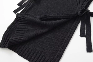 Détail du haut en maille noire avec texture côtelée et détails de laçage latéral